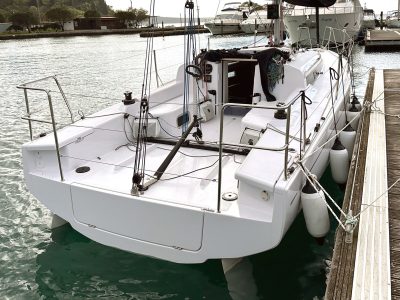 Weiße Segelyacht am Steg mit Fendern, Seilen und Cockpit sichtbar.