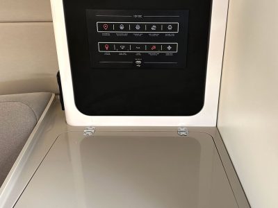 Waschmaschine mit geöffnetem Deckel, sichtbares Bedienfeld im Deckel.