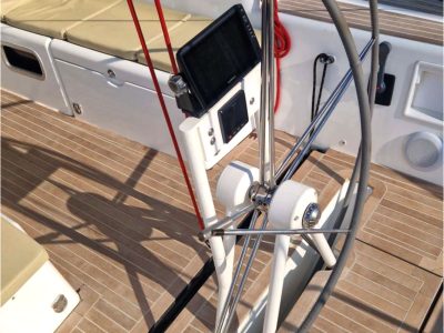 Segelboot-Cockpit: Steuerrad, Navigationsanzeige und rote Taue