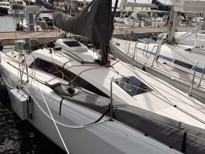 Segelboot im Yachthafen, Mastenreihen, Taue und Cockpit vor benachbarten Boote.