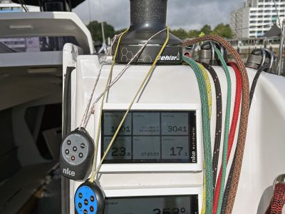 Segelboot-Cockpit mit Winsch, Navigationsdisplay und bunten Leinen.